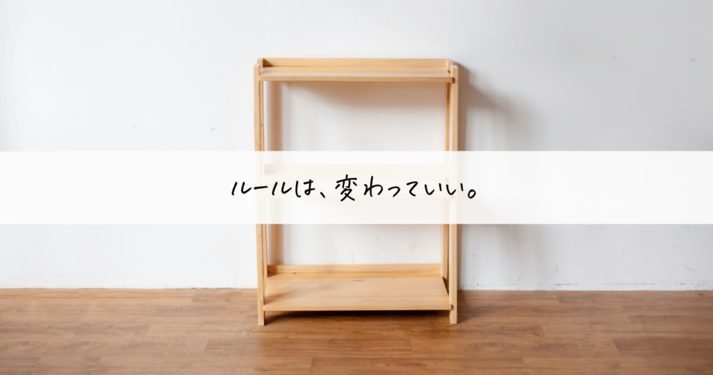木製のシンプルな棚を背景に、「ルールは、変わっていい。」という言葉が記されたミニマルな画像。